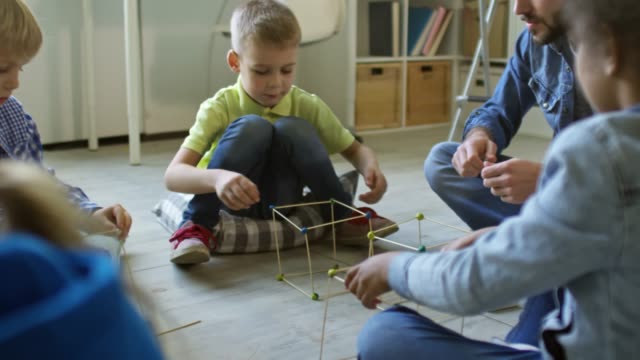 Group-of-Kids-Building-Cubes-with-Teacher