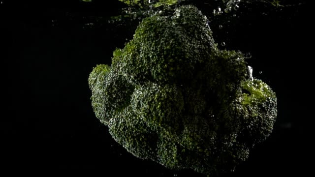 Falling-of-cabbage-of-broccoli-in-water.-Slow-motion.