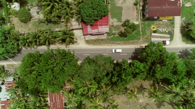 Aerial-view-following-car-on-road-in-Batuan,-Philippines.