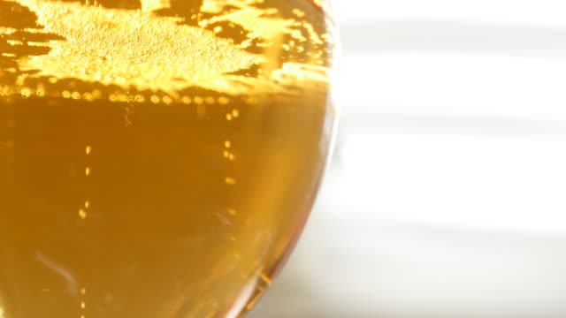 Glass-of-beer-slow-tilting-on-liquid-bubbles-4K
