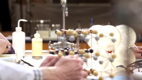 A-college-professor-helps-students-understand-a-chemistry-experiment