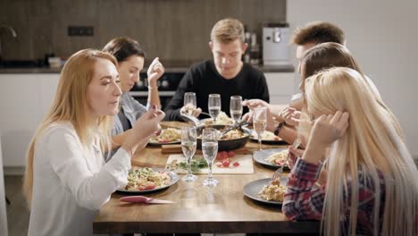 Happy-young-people-dinning-at-table-in-kitchen