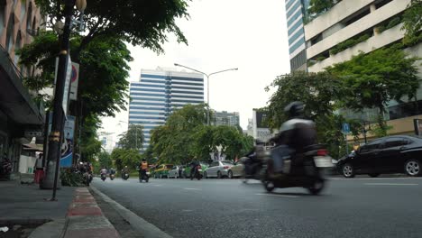 Motorbikes-moves-at-busy-street-in-the-downtown-at-summer-day,-bottom-view