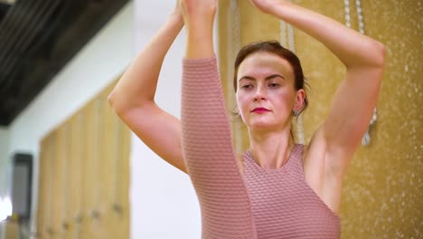 Young-woman-stretching-in-yoga-studio