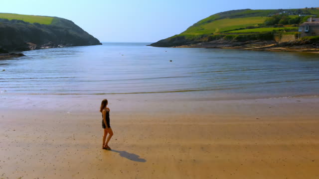 Woman-walking-on-the-beach-on-a-breezy-day-4k