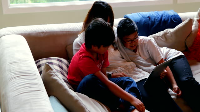 Mother-and-sons-using-digital-tablet-in-living-room-4k