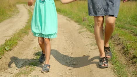 Mother-and-her-daughter-walking-along-a-rural-road