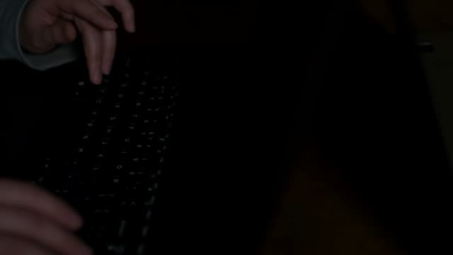 Hände-tippen-auf-Tastatur-in-Dunkelheit