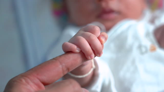 Babys-Hand-hält-den-Finger-der-Mutter.