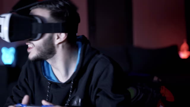 Junger-Mann-spielt-Spiele-mit-VR-Brille-und-Controller,-lächelnd-glücklich-genießen-die-Ausrüstung
