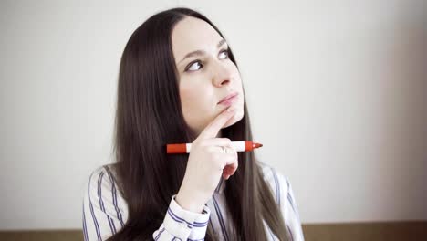 Thoughtful-young-woman-with-marker