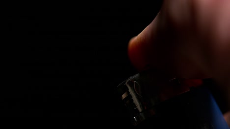 Hand-of-Man-who-Lights-a-Lighter-on-Black-Background,-Slow-Motion-4K