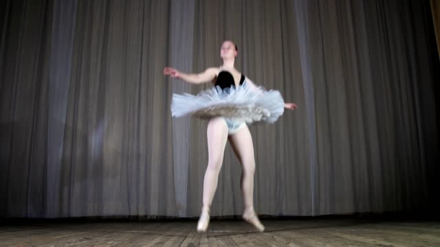 ballet-rehearsal,-on-the-stage-of-the-old-theater-hall.-Young-fat-ballerina-in-white-ballet-tutu-and-pointe-shoes,-try-to-dance-certain-ballet-motion,-glissad-en-tornant
