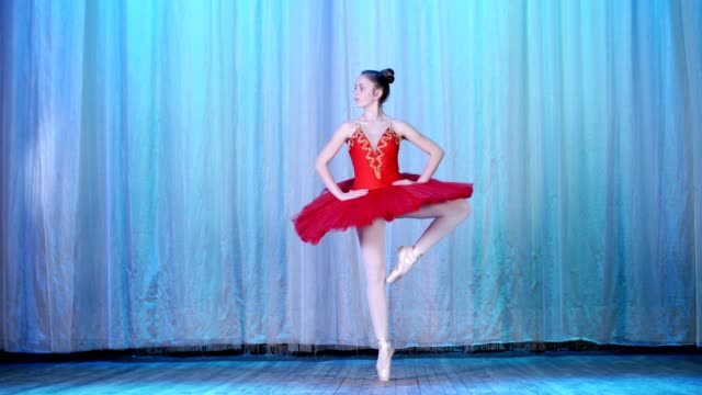 ballet-rehearsal,-on-the-stage-of-the-old-theater-hall.-Young-ballerina-in-red-ballet-tutu-and-pointe-shoes,-dances-elegantly-certain-ballet-motion,-sissone-simple