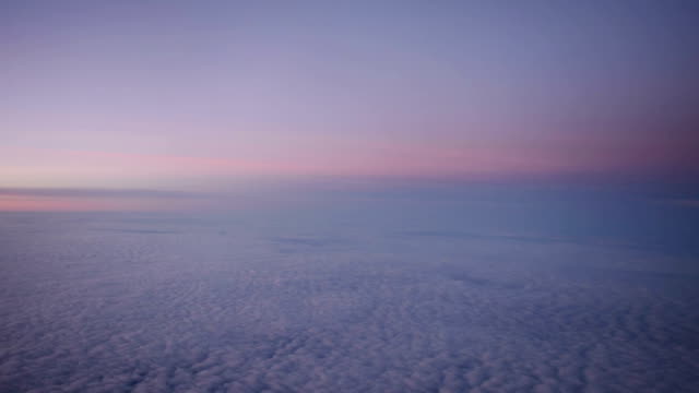 Nubes-púrpura-vistas-a-través-de-la-ventana-del-avión-a-reacción-en-la-puesta-de-sol.-HD-vídeo-alta-definición