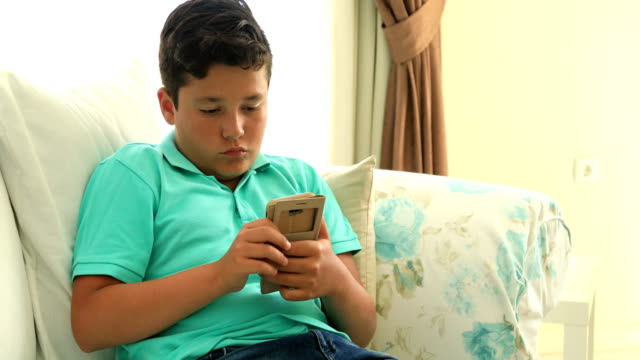 Young-boy-with-smartphone-at-home