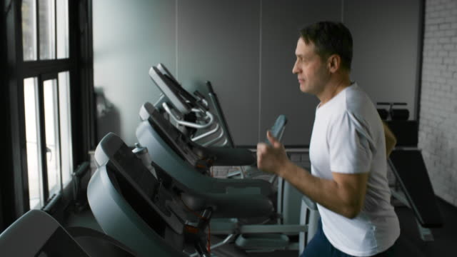 Athletic-Sportsman-Running-on-Treadmill-in-Gym