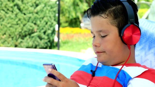 Young-boy-with-headphone-using-smartphone
