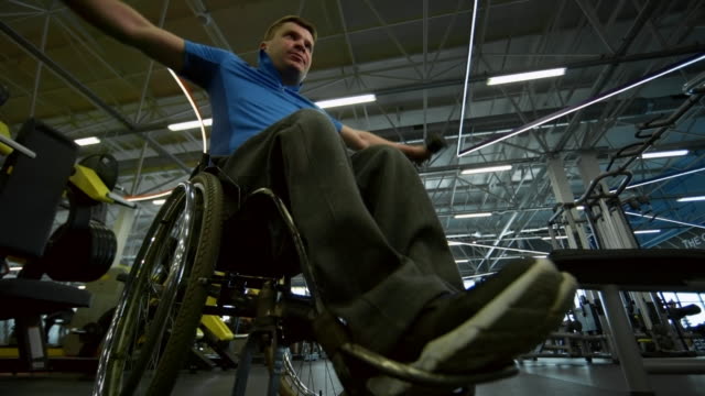Deportista-en-silla-de-ruedas-de-entrenamiento-con-pesas-en-gimnasio