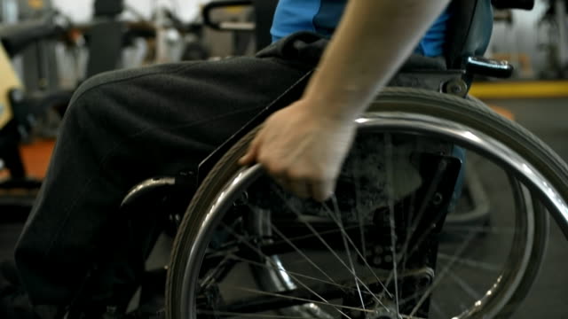 Unrecognizable-Man-in-Wheelchair-Riding-in-Gym
