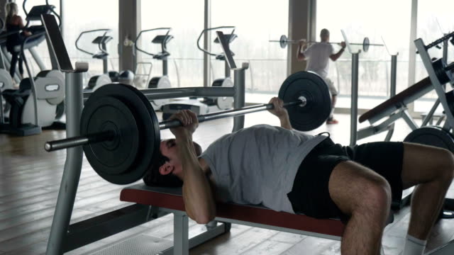Ein-nackter-Oberkörper-Kerl-in-der-Turnhalle-trainiert-seinen-Körper-Fit-zu-bleiben-und-Muskeln-definiert-haben.-Der-Athlet-stellt-sich-schweren-Gewichten-und-Müdigkeit.