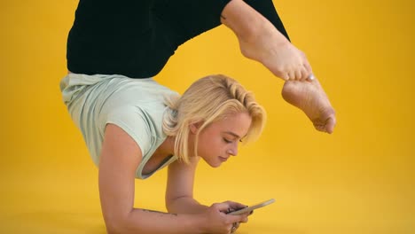 Caucasian-model-size-plus-practice-yoga-and-text-message-at-yellow-background