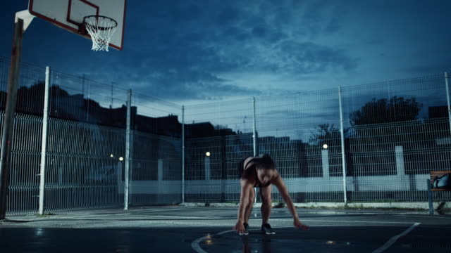 Beautiful-Energetic-Fitness-Girl-Doing-Jack-Burpee-Exercises.-She-is-Doing-a-Workout-in-a-Fenced-Outdoor-Basketball-Court.-Evening-Footage-After-Rain-in-a-Residential-Neighborhood-Area.