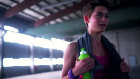 Woman-taking-a-break-from-exercises-with-a-water-bottle