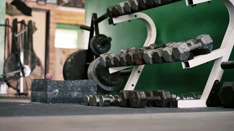 A-rack-of-dumbbells-in-a-small-gym-coming-into-focus
