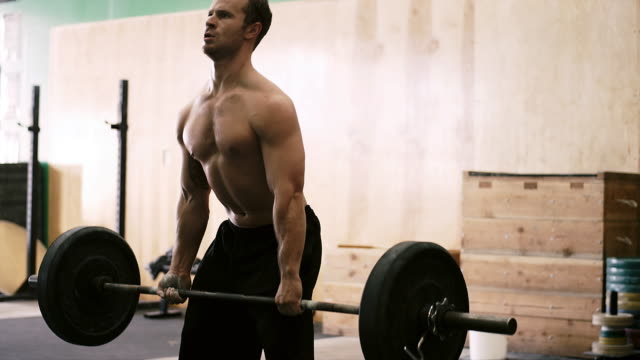 A-fit-young-man-doing-dead-lifts-at-a-small-gym