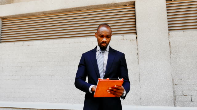 Hombre-de-negocios-americano-africano-soporte-con-tableta-al-aire-libre