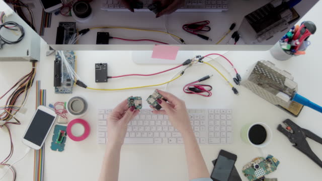 Female-electronics-engineer-examining-circuit-board
