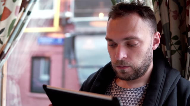 hübscher-bärtigen-Mann-mit-Tablet-Computer-Touchscreen-im-café
