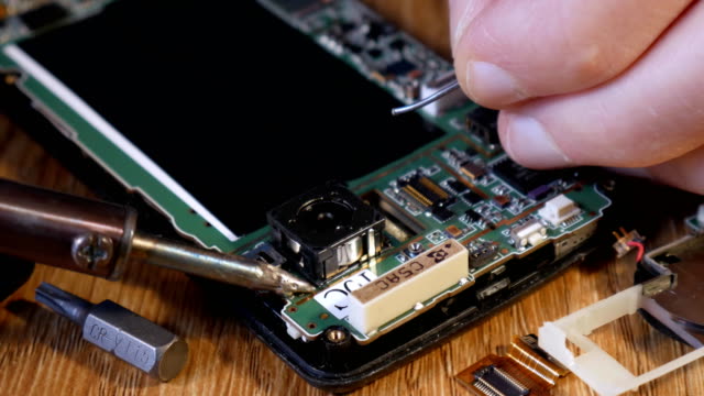 Soldering-smartphone-to-connect-two-contacts