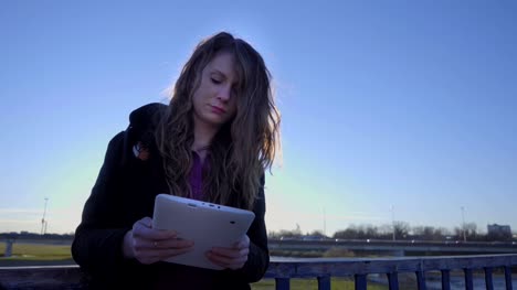 Woman-using-tablet-outside-at-sunset