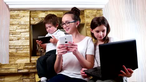 Kinder-damit-beschäftigt-ihre-elektronischen-Geräte,-kleiner-Junge-sieht-bewundernd-in-Schwestern-Tabletten-Bildschirm-zu-spielen