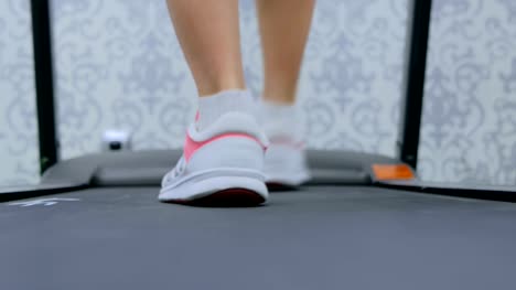 Athletic-young-woman-running-on-treadmill-at-the-gym