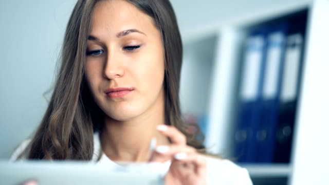 Attractive-businesswoman-using-a-digital-tablet-in-office