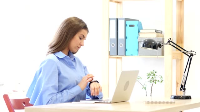 Junge-Frau-mit-Smartwatch,-sitzen-im-Büro