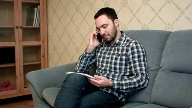 Mann-am-Telefon-zu-sprechen,-während-mit-tablet