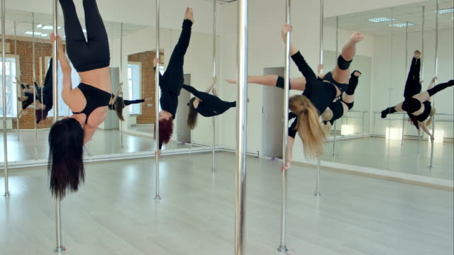 Fünf-sexy-schlanke-Frauen-Team-Poledance-training-im-Tanzsaal
