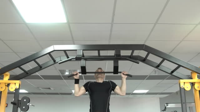 Strong-man-doing-pull-ups-in-a-gym