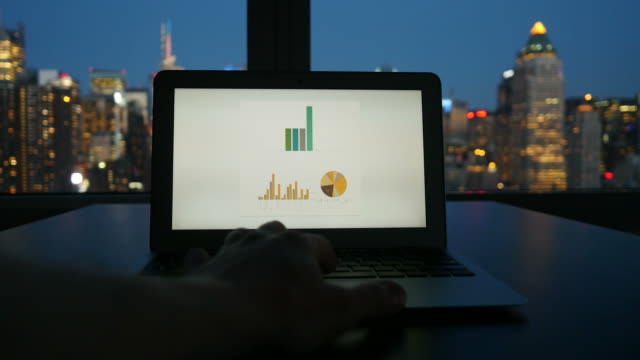 Digital-Device-Computer-with-Business-Figures-and-Banking-District-in-the-Background.