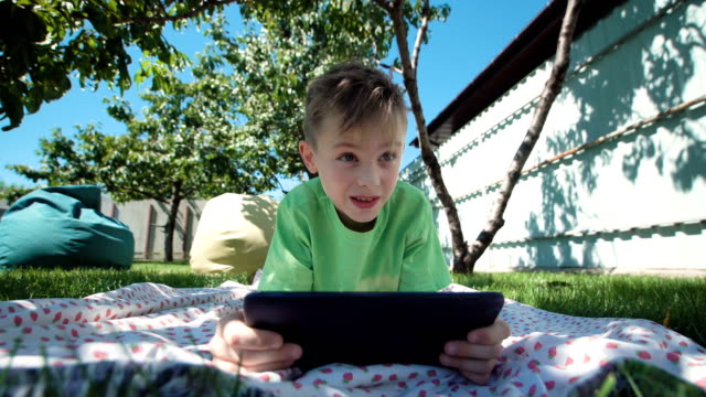 Junge,-die-Kommunikation-mit-Tablet-im-Garten