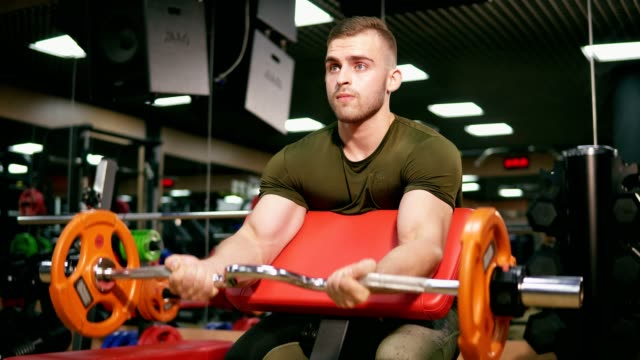 Young-adult-bodybuilder-doing-weight-lifting-training-his-biceps-in-gym.-On-the-verge-of-possibilities.-Shot-in-4k
