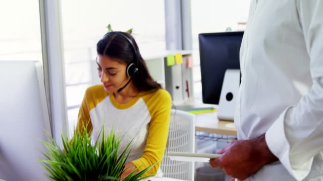 Executive-mit-Headsets,-die-mit-dem-Computer-am-Schreibtisch-im-Büro-4k