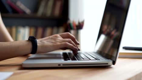 Woman's-hands-write-at-desktop-in-workplace