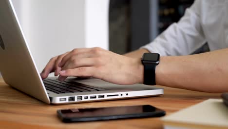 Man's-hands-close-up-type-at-pc-in-workspace