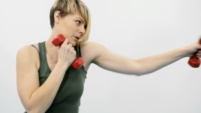 Woman-makes-punches-with-dumbbells-in-the-gym