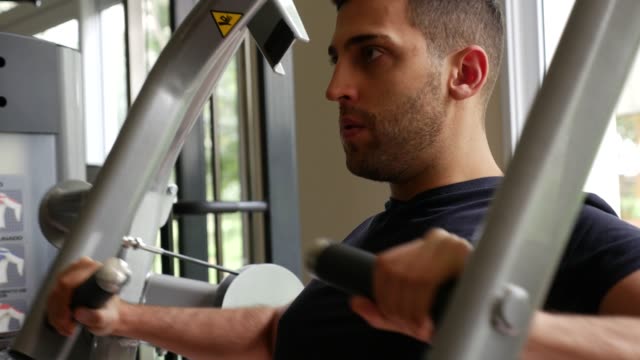Young-man-doing-chest-exercise-at-gym